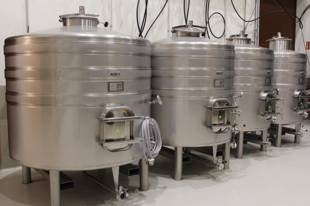 Depósitos de fermentación de acero inoxidable con tuberías y cuadros de control en Bodega Aalto